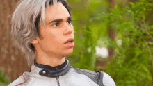 a young man with gray hair is wearing a white leather jacket
