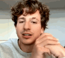 a close up of a man 's face with curly hair and a beard .