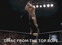a man is jumping in the air in a wrestling ring with the words `` dmac from the top rope '' .