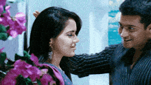 a man putting his hand on a woman 's head in front of purple flowers