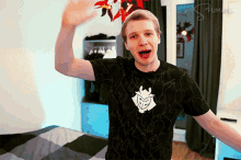 a man wearing a shirt that says g2 on it is standing in front of a bed