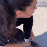 a woman is kneeling down and tying her shoelaces on a skateboard .
