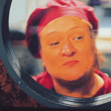 a woman in a pink hat is looking at herself in a mirror with the words trashy troll below her
