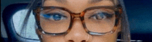 a close up of a woman wearing glasses and a nose ring .