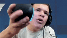 a man wearing headphones is holding a black ball