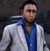 a man wearing a blue shirt and a grey jacket