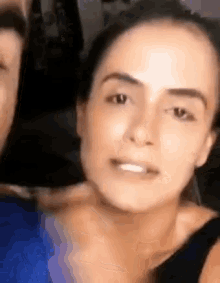 a close up of a woman 's face with a man in the background .