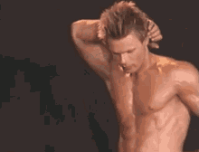 a man without a shirt is smiling with his mouth open and his teeth showing .