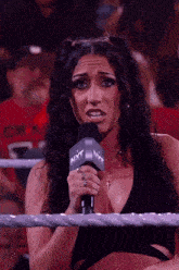 a woman in a wrestling ring holding a microphone that says nxt