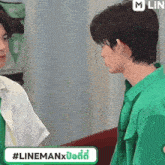 a man in a green shirt is looking at another man in a white shirt