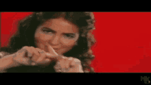 a woman is making a funny face while holding her finger to her lips .