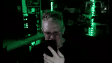 a man is taking a picture of himself with a cell phone in a dark room .