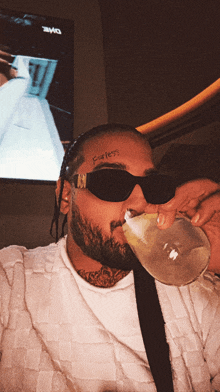 a man with a tattoo on his forehead that says fearless drinks from a glass