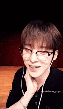 a young man wearing glasses and ear buds is smiling for the camera