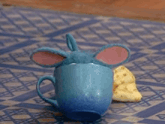 a blue toy is sitting on a blue and white checkered mat eating a banana .