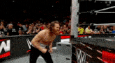 a man without a shirt is standing in a wrestling ring .