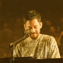 a man is singing into a microphone while playing a piano .