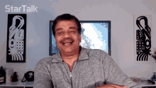 a man is smiling in front of a startalk logo