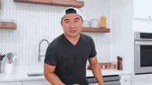a man is standing in a kitchen with the words made in animatica on the bottom right