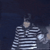a man in a black and white striped shirt is making a funny face