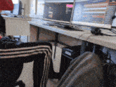 a person is sitting at a desk with a computer monitor on it