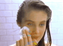 a woman wipes her face with a cotton swab