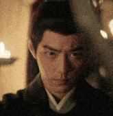 a man with a ponytail is looking at the camera