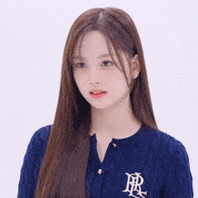 a girl wearing a blue sweater with the letter r on the front