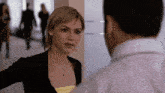 a woman talking to a man in a hallway