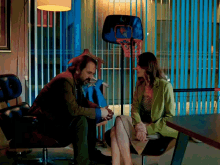 a man and woman are sitting in front of a basketball hoop