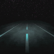 a dark road with a glowing line in the middle of it