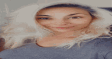 a woman with blonde hair is smiling for the camera