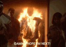 a damn hope i 'm next message is displayed in front of a burning man