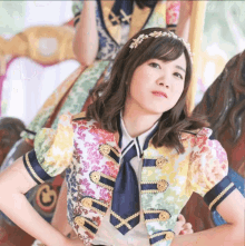 a girl in a colorful outfit has the letter a on her head
