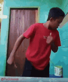a young man wearing a red shirt with the word kef on it