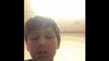 a young boy with his eyes closed is looking at the camera