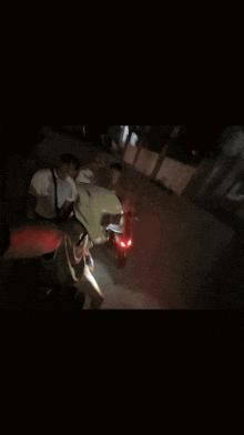 a man wearing a helmet that says ' yamaha ' on it is standing next to two other men
