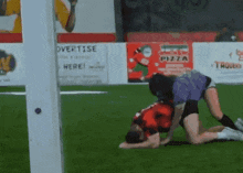 a soccer game is being played in front of a sign that says overtise
