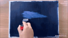 a person is painting on a canvas with the words made in animatica on the bottom right