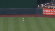 a baseball player runs towards a clean power sign