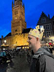 a man wears a burger king crown in front of a castle