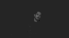 a black and white photo of a man with a beard and a hoodie