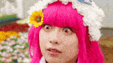 a woman with pink hair and a flower in her hair looks surprised