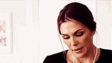 a woman is wearing a black shirt and a necklace .