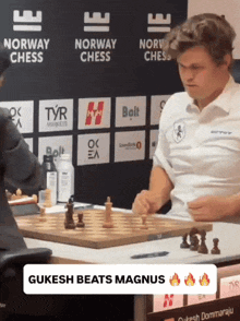 a man playing chess in front of a norway chess banner