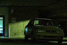 a man in a suit is driving a car with a green background