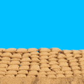 a man wearing headphones stands in front of a pile of sandbags with the word bau written above him