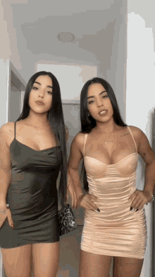two women standing next to each other wearing dresses