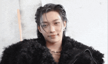the woman is wearing a fur coat and a necklace .