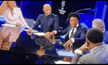 a group of people sitting around a table with champions league written on it